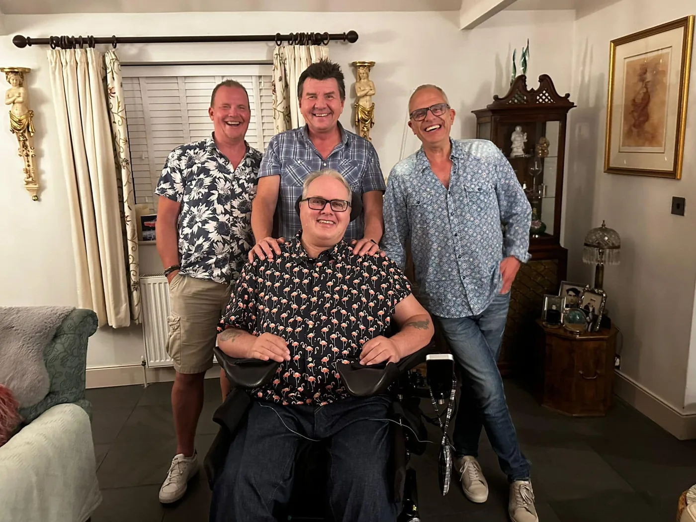 Marc smiling with three other people at an indoor gathering