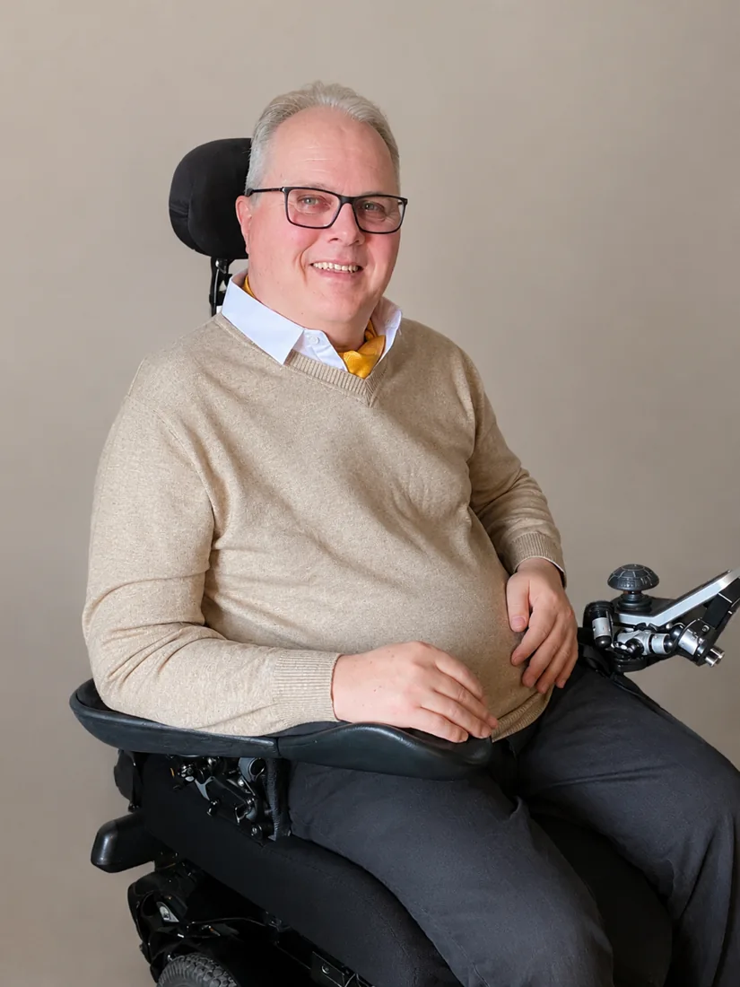 Marc ‘Woody’ Wodehouse smiling, seated in his wheelchair